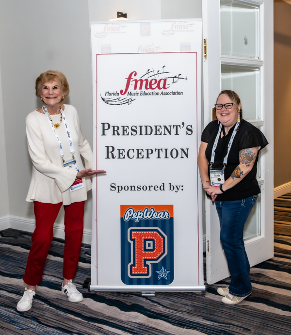 Mary Palmer and Amanda Crawford posing in front of the President's Reception sign sponsored by PepWear