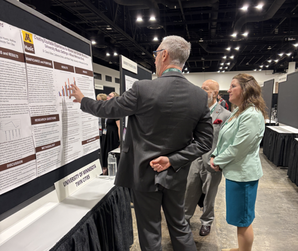 Photo of a researcher discussing his poster with attendees
